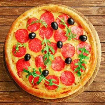 Pizza con queso, tomates cherry y albahaca